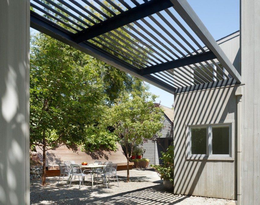 En metal baldakin er placeret mellem to bygninger i en privat gårdhave En metal baldakin er placeret mellem to bygninger i en privat gårdhave