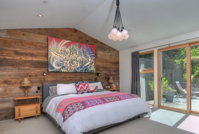 המיטה ממוקמת בסמוך לקיר המעוטר בלוחות עץ המיטה ממוקמת בסמוך לקיר המעוטר בלוחות עץ