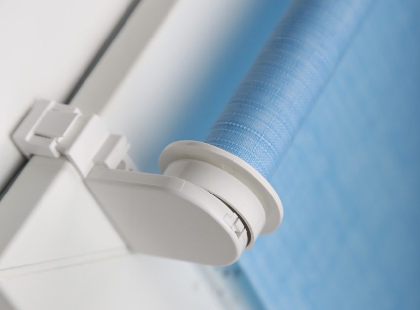 Roleta nawinięta jest na plastikowy trzonek przymocowany do ramy okiennej Roleta nawinięta jest na plastikowy trzonek przymocowany do ramy okiennej