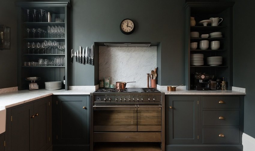 Facaden på køkkenmøblerne og væggene er malet med den samme mørkegrå maling Facaden på køkkenmøblerne og væggene er malet med den samme mørkegrå maling
