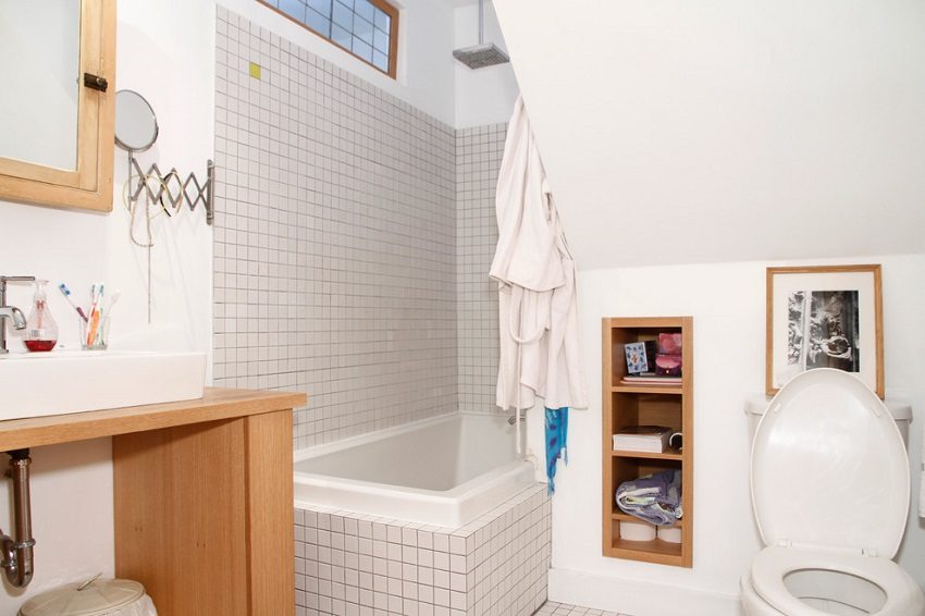 Die Badewanne befindet sich in der Nische des Badezimmers Die Badewanne befindet sich in der Nische des Badezimmers