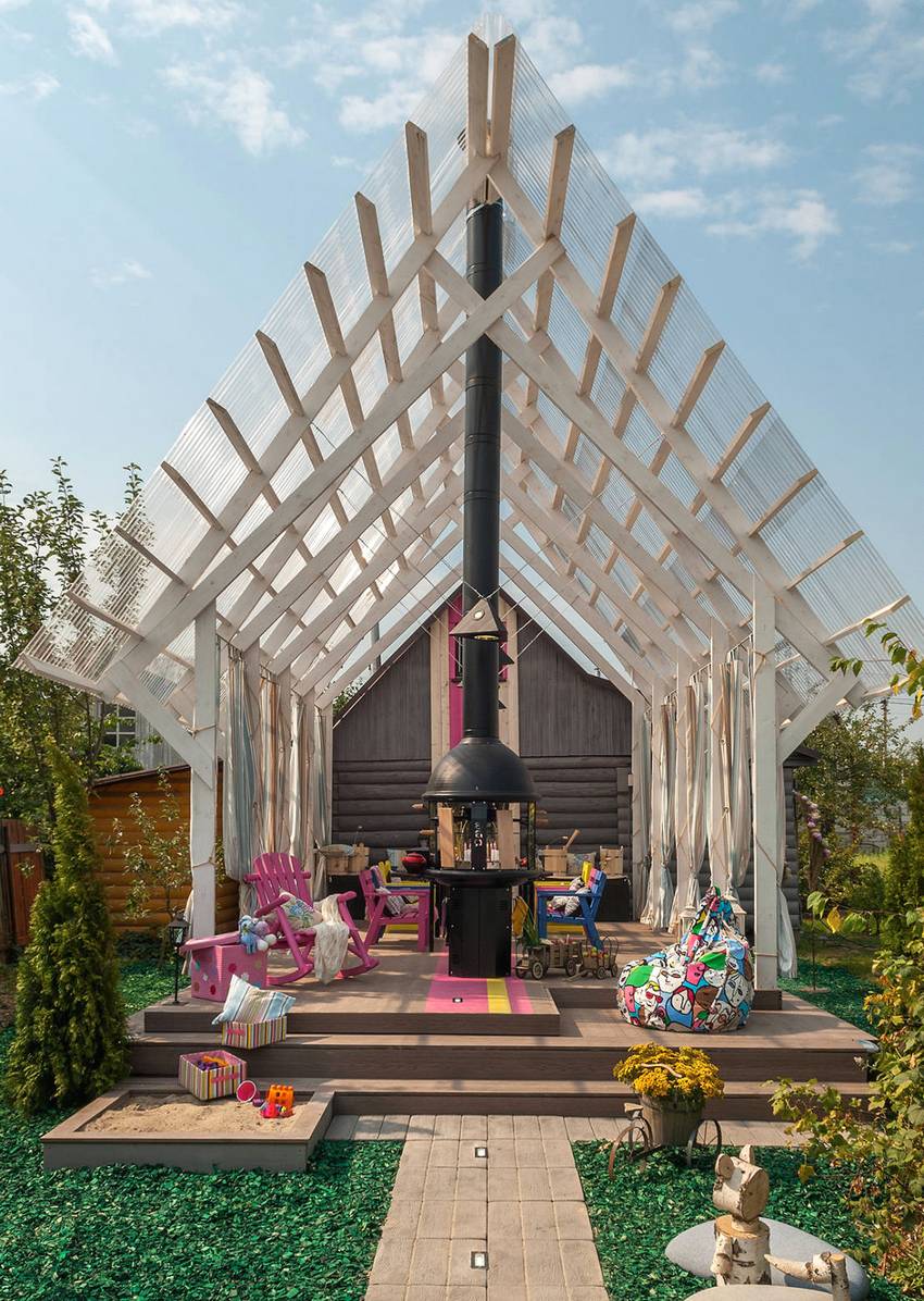 Un hangar inhabituel avec un toit à pignon attaché à une maison en bois Un hangar inhabituel avec un toit à pignon attaché à une maison en bois