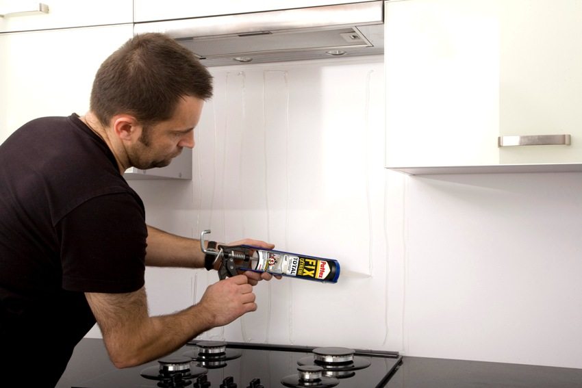 לפני התקנת הסינר, דבק מיוחד מוחל על הקיר לפני התקנת הסינר, דבק מיוחד מוחל על הקיר