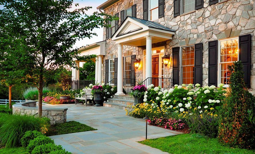 Blomsterbed pryder facaden og indgangsgruppen til sommerhuset Blomsterbed pryder facaden og indgangsgruppen til sommerhuset