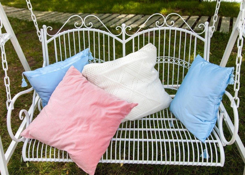 Painoton ulkonäkö ja siro taottu keinu värikkäillä tyynyillä Painoton ulkonäkö ja siro taottu keinu värikkäillä tyynyillä