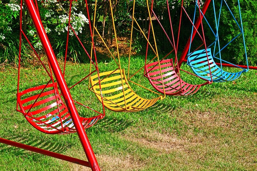 Kirkas lasten keinu, valmistettu metallista ja A-muotoiset tukipylväät Kirkas lasten keinu, valmistettu metallista ja A-muotoiset tukipylväät