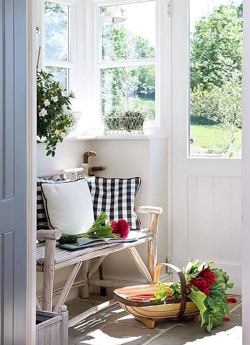 A bench made of logs is installed on a closed veranda of a country house A bench made of logs is installed on a closed veranda of a country house