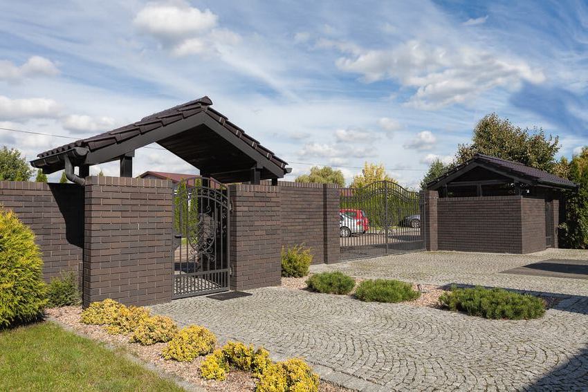 Ang teritoryo ng isang pribadong bahay ay napapaligiran ng bakod na brick Ang teritoryo ng isang pribadong bahay ay napapaligiran ng bakod na brick