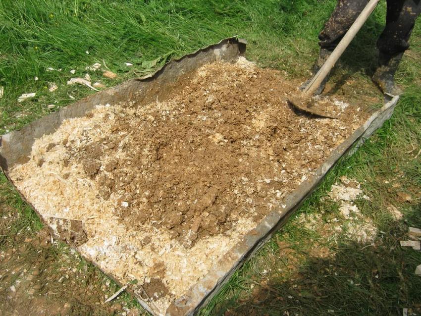 Vorbereitung für die Dämmung der Decke in einem Haus mit kaltem Dach: Mischen von Sägemehl mit Ton Vorbereitung für die Dämmung der Decke in einem Haus mit kaltem Dach: Mischen von Sägemehl mit Ton