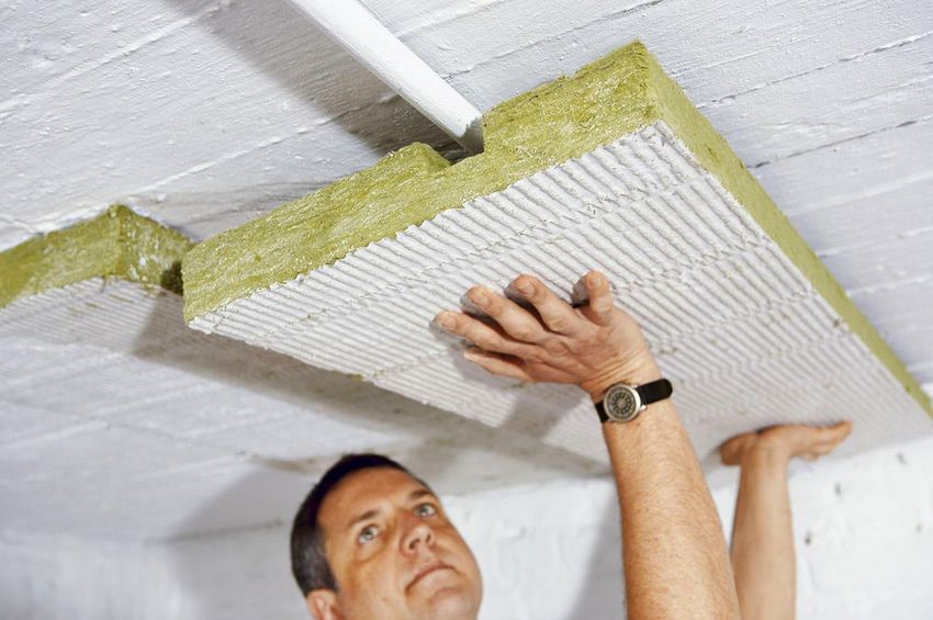 Der Prozess der Isolierung der Decke von der Seite des Untergeschosses Der Prozess der Isolierung der Decke von der Seite des Untergeschosses