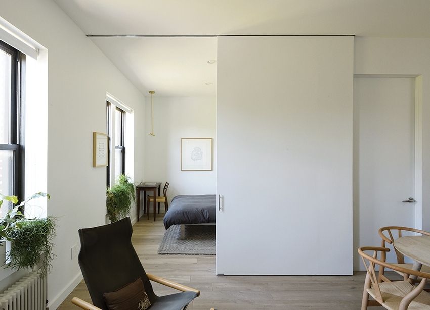 O partiție funcțională care separă dormitorul și camera de zi într-un apartament mic de oraș O partiție funcțională care separă dormitorul și camera de zi într-un apartament mic de oraș