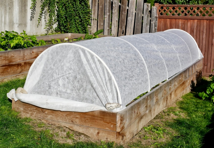 Dekningsmateriale kan ikke festes til buer, men bruk tunge steiner eller murstein for å feste det ved bunnen av drivhuset Dekningsmaterialet kan ikke festes til buene, men bruk tunge steiner eller murstein for å feste det ved bunnen av drivhuset