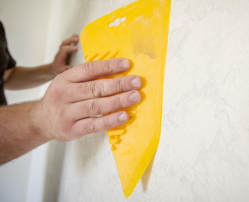 Kun tapetti on liimattu seinään, on tarpeen päästä eroon ilmakuplista erityisellä lastalla Kun tapetti on liimattu seinään, on tarpeen päästä eroon ilmakuplista erityisellä lastalla