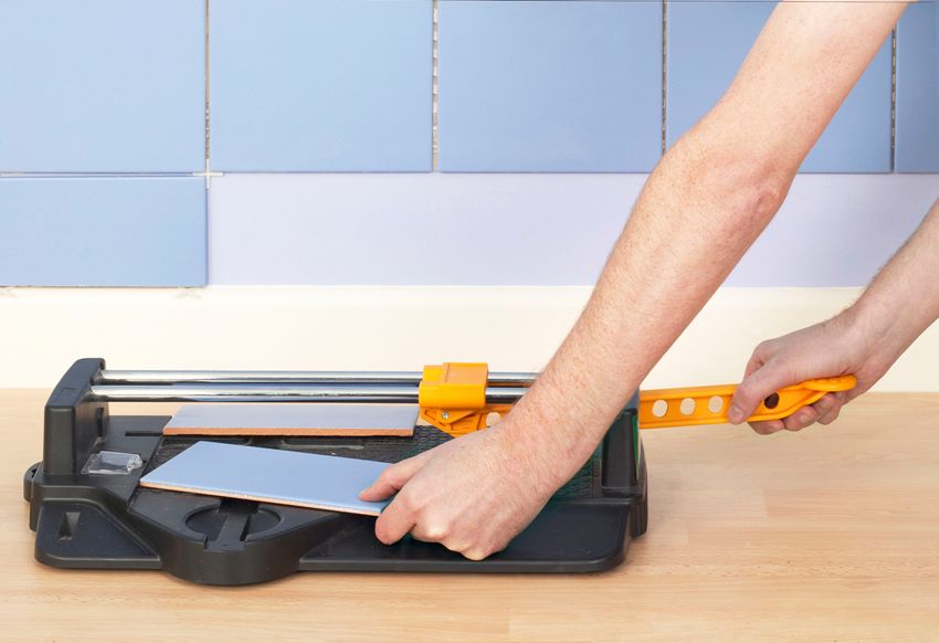 Sawing ceramic tile na may isang manu-manong pamutol ng tile Sawing ceramic tile na may isang manu-manong pamutol ng tile