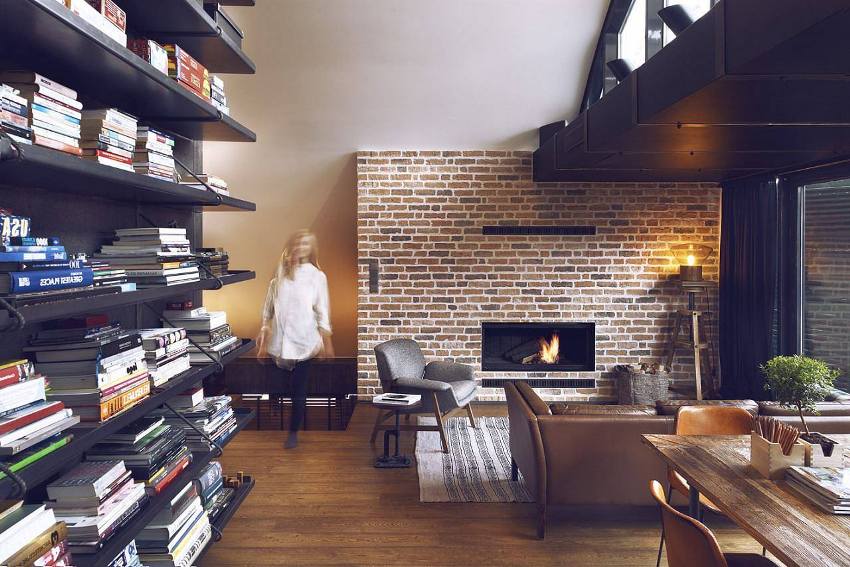 ห้องนั่งเล่นใต้หลังคาแสนสบายพร้อมเตาผิงและชั้นหนังสือแบบเปิด ห้องนั่งเล่นใต้หลังคาแสนสบายพร้อมเตาผิงและชั้นหนังสือแบบเปิด
