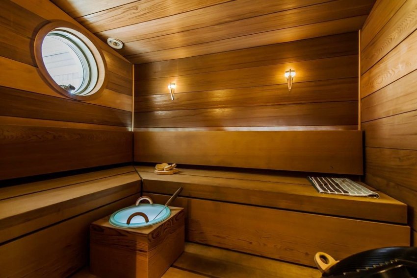 Trehyller i form av bokstaven L er plassert på den ene siden motsatt varmeovnen, og den andre på den ene av de frie veggene Trehyller i form av bokstaven L er plassert på den ene siden motsatt varmeovnen, og den andre på den ene av de frie veggene