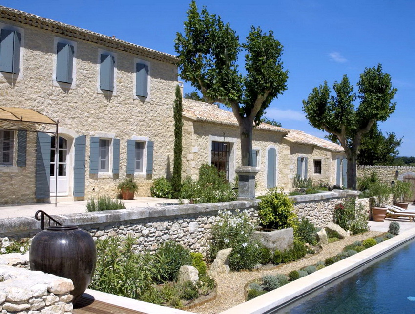 מעקות אבן ועציצים גדולים של צמחייה עוזרים להדגיש את המבטאים העיקריים בעיצוב החצר מעקות אבן ועציצים גדולים של צמחייה עוזרים להדגיש את המבטאים העיקריים בעיצוב החצר