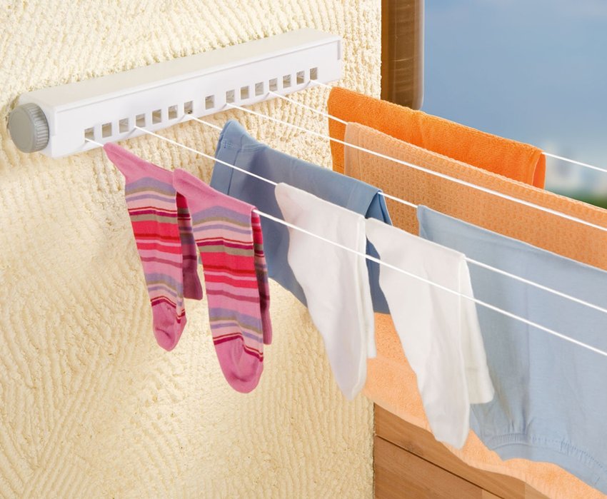 Skladacia konštrukcia sušičky sa skladá z dvoch častí, ktoré sú pripevnené k protiľahlým stenám a medzi nimi sú ťahané šnúry Skladacia konštrukcia sušičky sa skladá z dvoch častí, ktoré sú pripevnené k protiľahlým stenám a medzi nimi sú ťahané šnúry