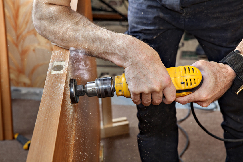 For at lave et hul til et håndtag og en lås skal du bruge en skruetrækker med en krone til træ For at lave et hul til et håndtag og en lås skal du bruge en skruetrækker med en krone til træ