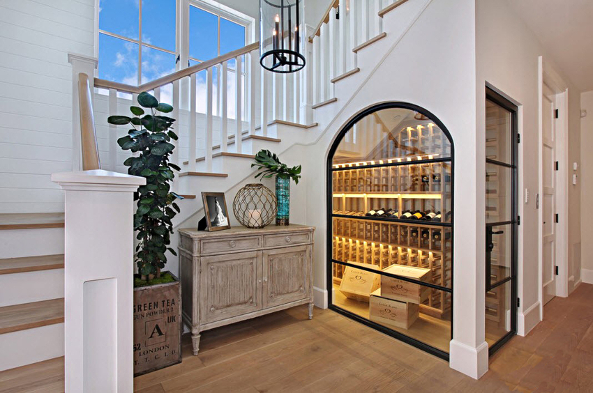 Tilstedeværelsen av glass i skapet under trappen hindrer støv i å sette seg på hyllene og fungerer som et element av spektakulær design Tilstedeværelsen av glass i skapet under trappen hindrer støv i å sette seg på hyllene og fungerer som et element av spektakulær design