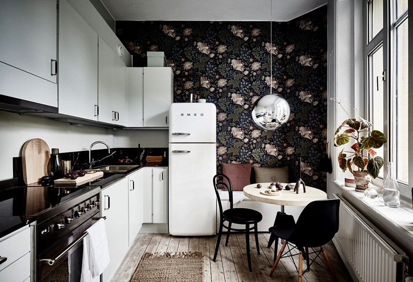 A világos konyhai szett és a falakon sötét háttérképek merésznek és a dobozon kívülinek tűnnek A világos konyhai szett és a falakon sötét háttérképek merésznek és a dobozon kívülinek tűnnek