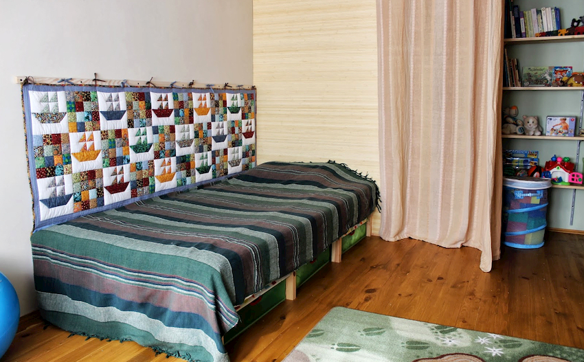 Problemet med at gnide væggen i soveområdet kan løses på en måde - hæng et børnetæppe på væggen Problemet med at gnide væggen i soveområdet kan løses på en måde - hæng et børnetæppe på væggen