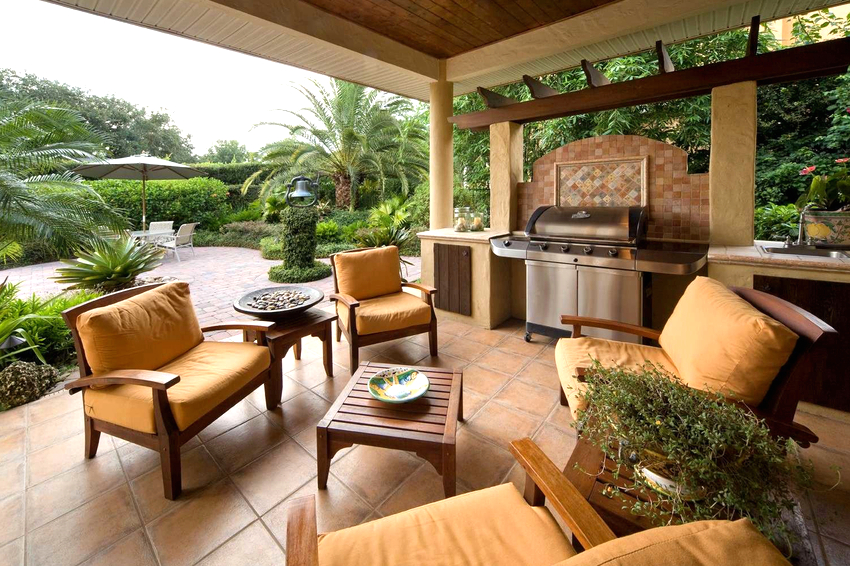 מנגל מקורה מונח מתחת לחופה, שולחן מונח לידו ומאובזרים בישיבה מנגל מקורה מונח מתחת לחופה, שולחן מונח לידו ומאובזרים בישיבה